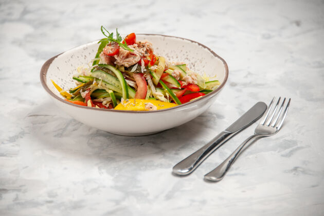 菜肴特写镜头鸡肉沙拉与蔬菜和餐具设置在染色的白色表面晚餐西红柿鸡肉沙拉