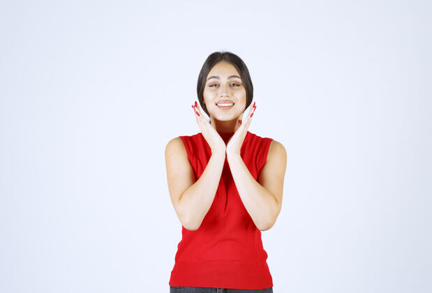 微笑穿红衬衫的女孩摆出中性 积极和吸引人的姿势女人人满意