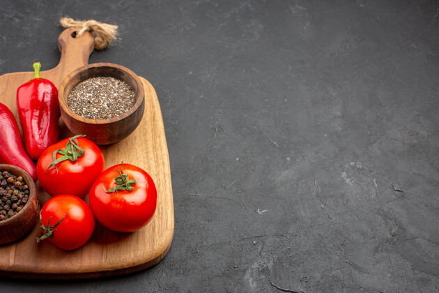 食品前视图新鲜的红色番茄与调味品对黑暗的空间容器饮食托盘