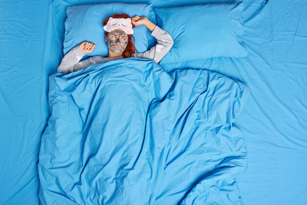 卧室女人躺在舒适的床下 把面膜戴上睡衣 睡衣感到寂寞女人眼罩不高兴