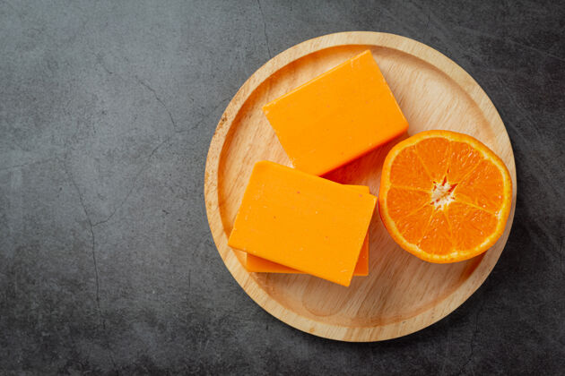 浴室橙色肥皂与新鲜的橙色在黑暗的背景橘子草药浴缸