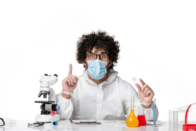 溶液男医生穿着防护服 戴着口罩 用白色溶液工作实验室外套外套防护