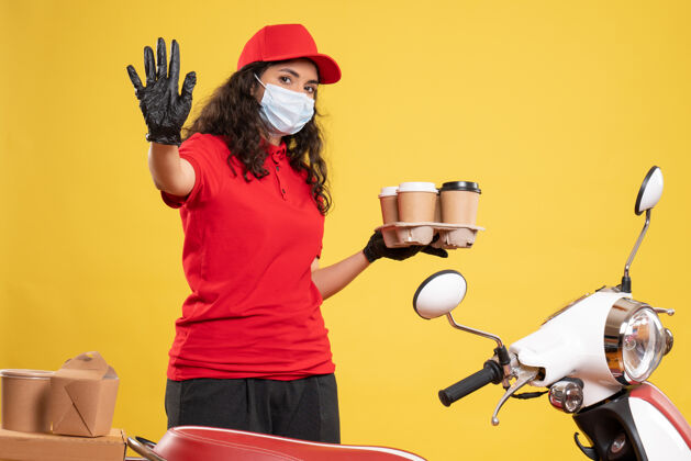 工作正面图穿着红色制服的女信使 黄色背景上有咖啡杯工人柯维德-大流行的工作制服服务病毒制服人咖啡