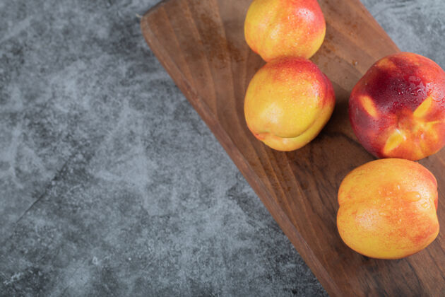 奶油黄红色的桃子放在木盘上喜悦健康面包房
