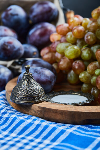 葡萄桌布上放着新鲜的李子和一串葡萄水果农业浆果