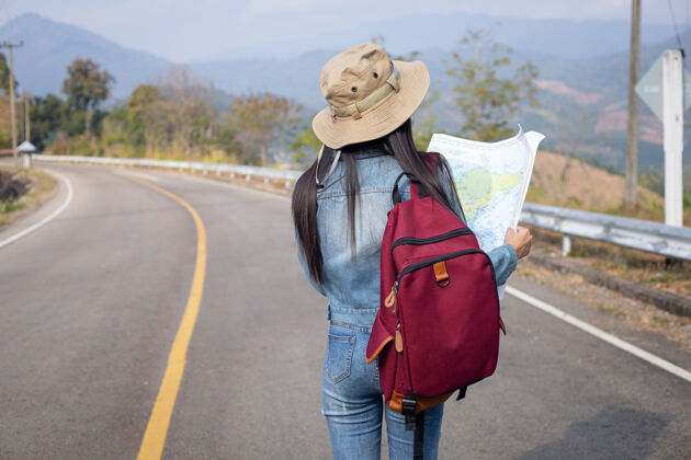 外科口罩旅游女孩在地图上寻找正确的方向成人背包亚洲