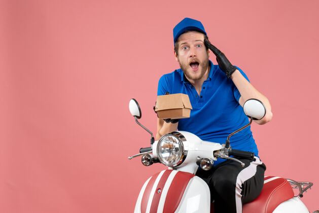 工作正面图男性信使坐在自行车上 拿着一个粉红色的小食品包制服快餐送货