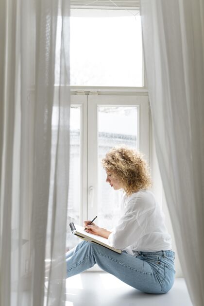放松一位年轻女子在家里靠窗画画的侧视图素描休闲和平