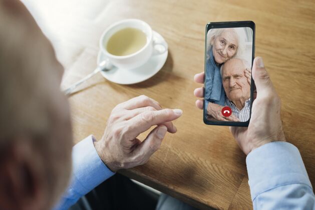 老年人一个老人通过视频电话和他的朋友交谈虚拟视频通话视频