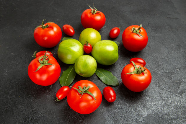 西红柿底图红绿色和樱桃番茄和月桂叶在黑暗的背景叶有机食品