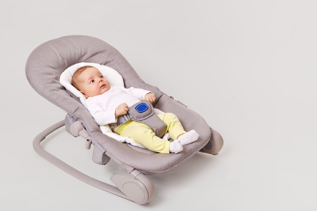 童年侧视图迷人的新生儿女孩躺在弹跳儿童保镖椅子睡衣舒适婴儿