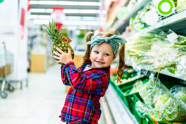 菠萝超市里站着拿着菠萝的小孩买小女孩女孩