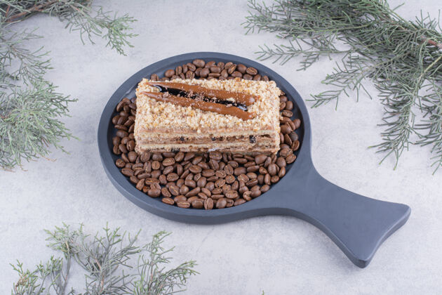 切片美味的蛋糕放在深色的木板上 配上咖啡豆面包房甜点小块