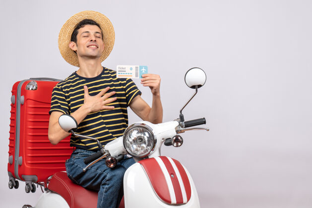 摩托车一个戴着草帽 手放在胸前 手持飞机票的年轻人轻便摩托车摩托车视图