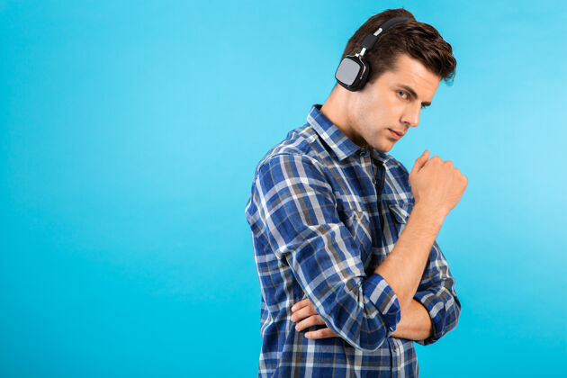 时髦坐在蓝色耳机上听音乐的男人的画像无线休闲人物