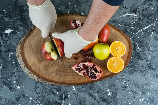 刀男手切红苹果放在桌上的木板上石榴有机苹果