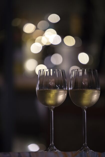 特写垂直选择焦点拍摄的两杯饮料与模糊的灯光背景冷立方体黄