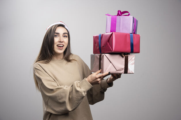 礼物年轻女子手里拿着三盒圣诞礼物携带女性盒子