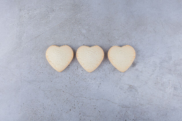 美味美味的饼干放在心形的石头桌上爱心饼干