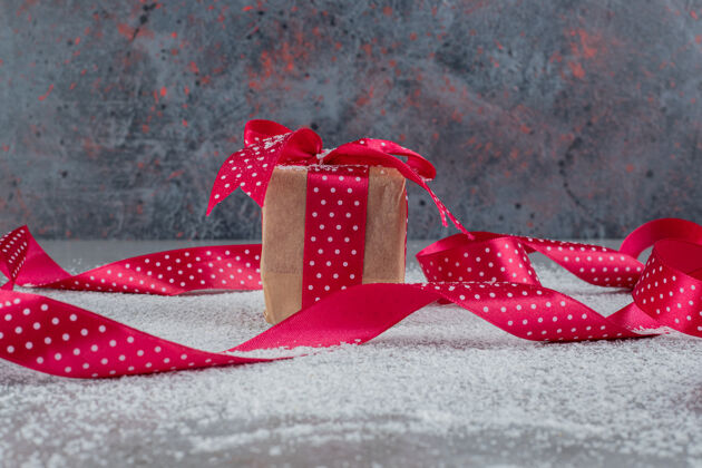 粉小礼品盒和波尔卡点缀丝带椰子粉大理石表面礼物礼品盒丝带