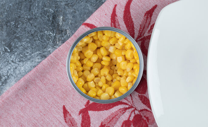 谷类一罐爆米花籽 空盘子放在桌布上自然食物甜玉米