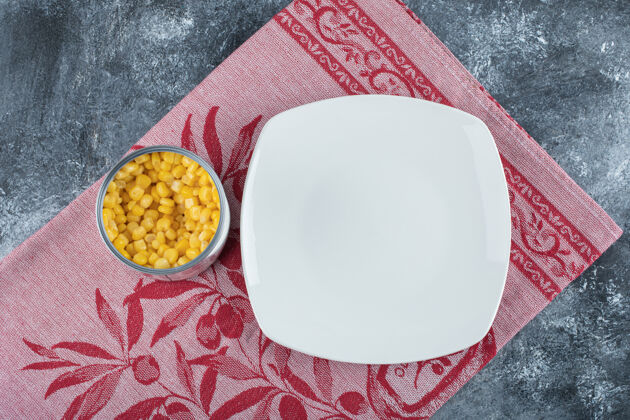 自然一罐爆米花籽 空盘子放在桌布上桌布顶视图食物