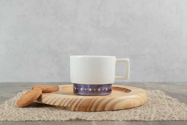 饼干一杯咖啡和饼干放在木盘上营养杯子热的