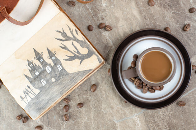 香味咖啡杯 咖啡豆和笔记本放在大理石表面配料烤