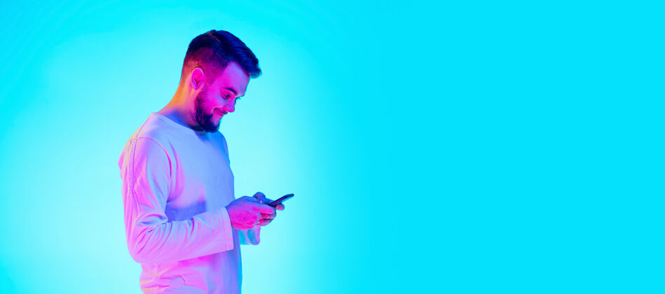 企业白种人的肖像在霓虹灯下的蓝色工作室背景上孤立美丽的男模人类情感的概念 面部表情 销售 广告广告的复制空间热带脸成功