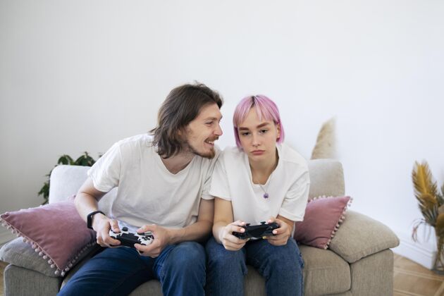 室内可爱的情侣在室内玩电子游戏享受视频游戏娱乐