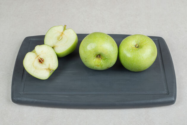 营养在深色的盘子上切一整块半的青苹果苹果食品新鲜