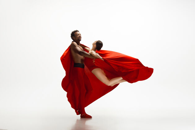 艺术家优雅的经典芭蕾舞者在白色的工作室背景上独立地跳舞一对穿着鲜红衣服的舞者就像是酒和牛奶的结合优雅 艺术家 动作 动作的概念姿势芭蕾舞牛奶