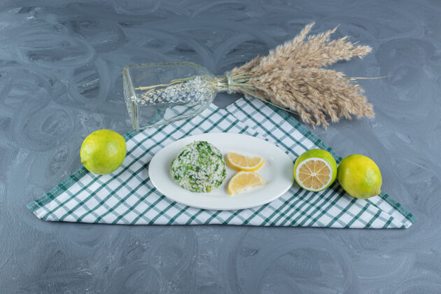 烹饪在一张折叠的桌布上放上一份带柠檬的米饭 旁边是大理石桌上装饰性的一捆羽毛草切片干燥美味