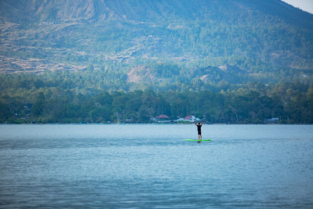 热带一个男人在湖边骑冲浪板湖泊自然人