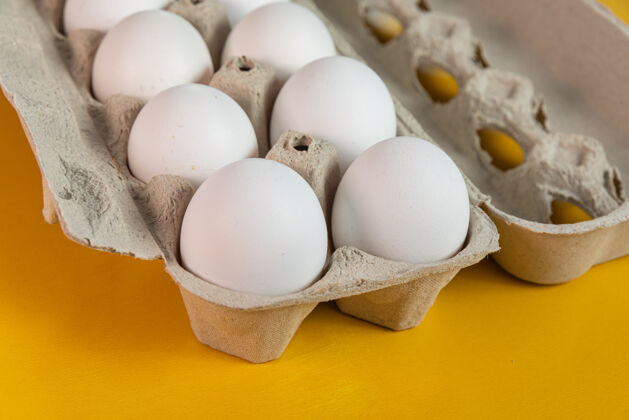 艺术黄色表面上有鸡蛋生的鸡蛋盒美食家