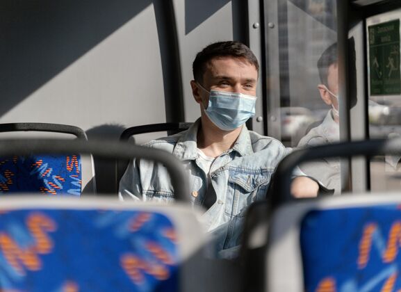 交通年轻人戴着口罩坐公交车城市男人旅行