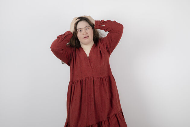 低垂一个患有唐氏综合症的可爱女孩站着摆姿势的照片女性综合症女人