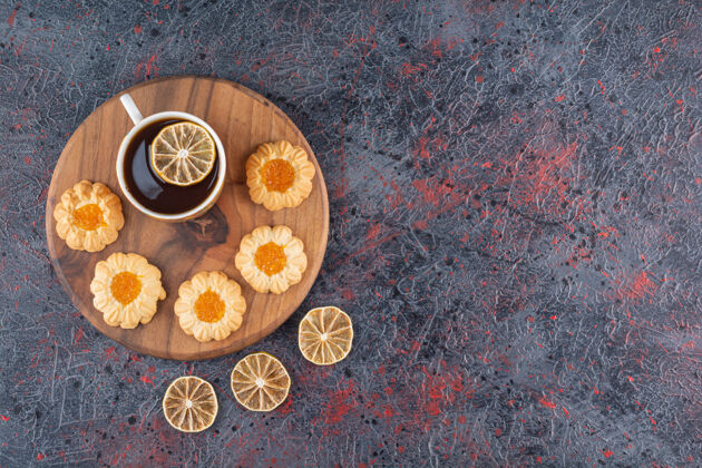 小吃木板上茶和自制饼干的俯视图仍然烘焙甜点