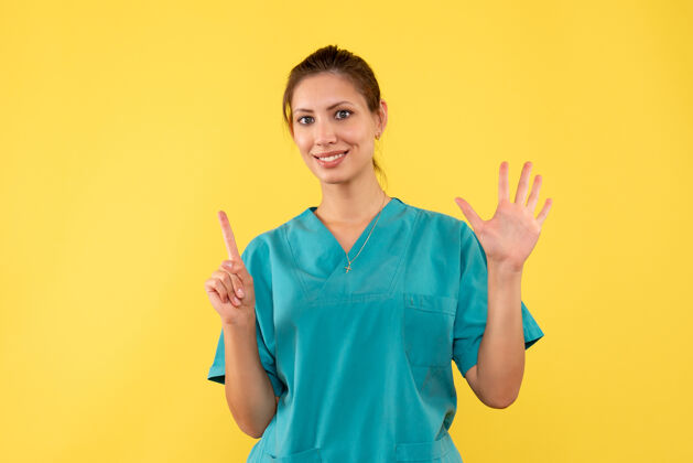 休闲前视图黄色背景上穿着医用衬衫的女医生医疗健康护士
