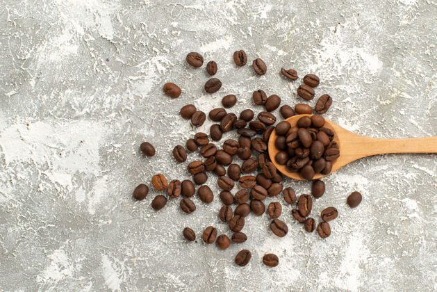 顶视图棕色咖啡籽新鲜的白色背景咖啡籽颗粒背景种子新鲜