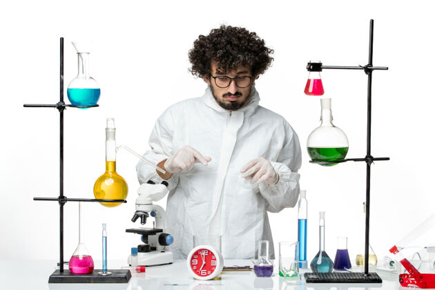 到处正面图身着特殊套装的年轻男性科学家站在桌子周围 白色墙壁上有解决方案研究溶液实验室