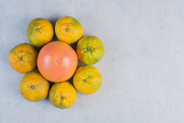 配料一堆橘子围绕着一堆柚子 背景是灰色的新鲜灰色明亮