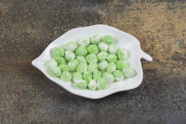 糖果绿色薄荷醇糖放在叶子形状的盘子里芳香薄荷邦邦