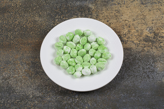 邦邦白色盘子上的绿色薄荷醇糖果薄荷芳香糖果