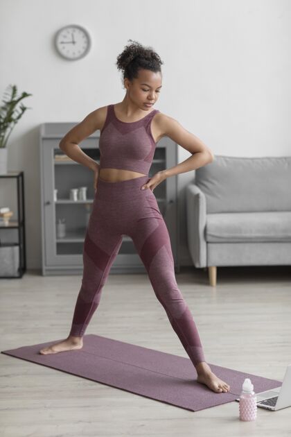 房子健身女士在家里用瑜伽垫做瑜伽身体内心的和平和平