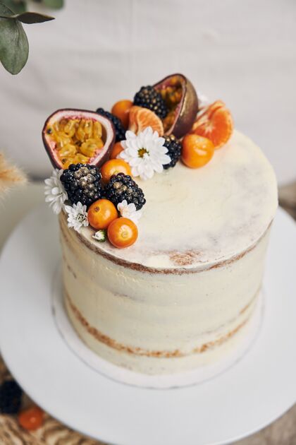 甜点白色的蛋糕和浆果和西番莲紧挨着一棵植物 背景是白色的切片派浆果
