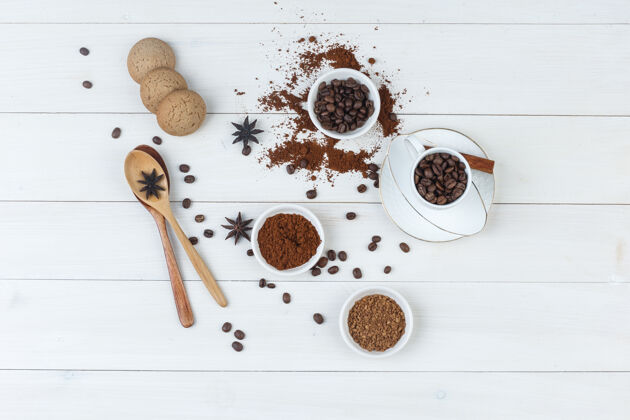 宏顶视图咖啡豆在杯子和碗与研磨咖啡 香料 饼干 木制背景上的木制勺子水平咖啡阿拉伯语美食