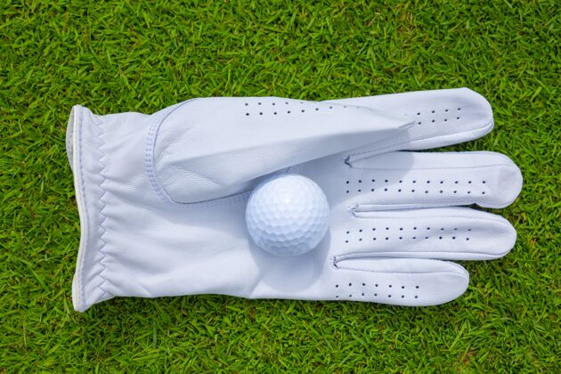 司机阳光下草坪上戴着手套的高尔夫球的高角度特写镜头高尔夫高尔夫球