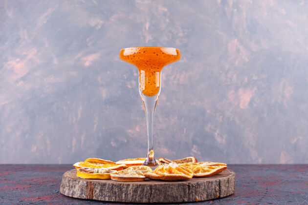 柑橘一杯新鲜鸡尾酒和干柑橘类水果放在木片上新鲜多汁水果