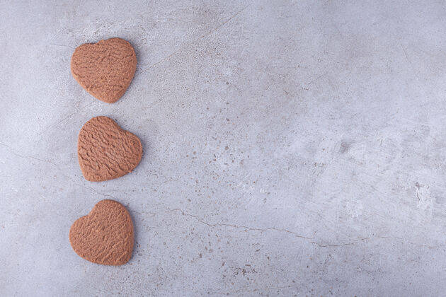 糕点香喷喷的新鲜心形饼干放在石头上可可美味形状